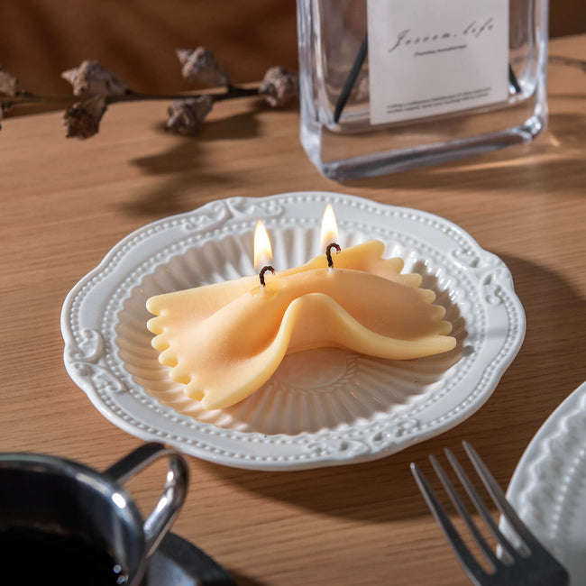 Realistic Farfalle Food Pasta Candle is lit up and sitting on the plate by Southlake Gifts Canada. 