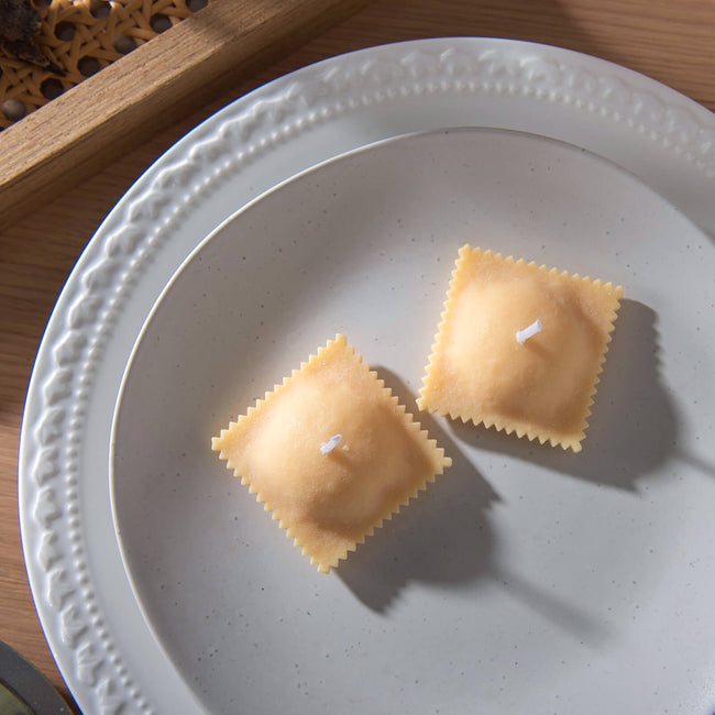 Realistic Ravioli Food Pasta Candle is sitting on the white plate by Southlake Gifts Canada. 