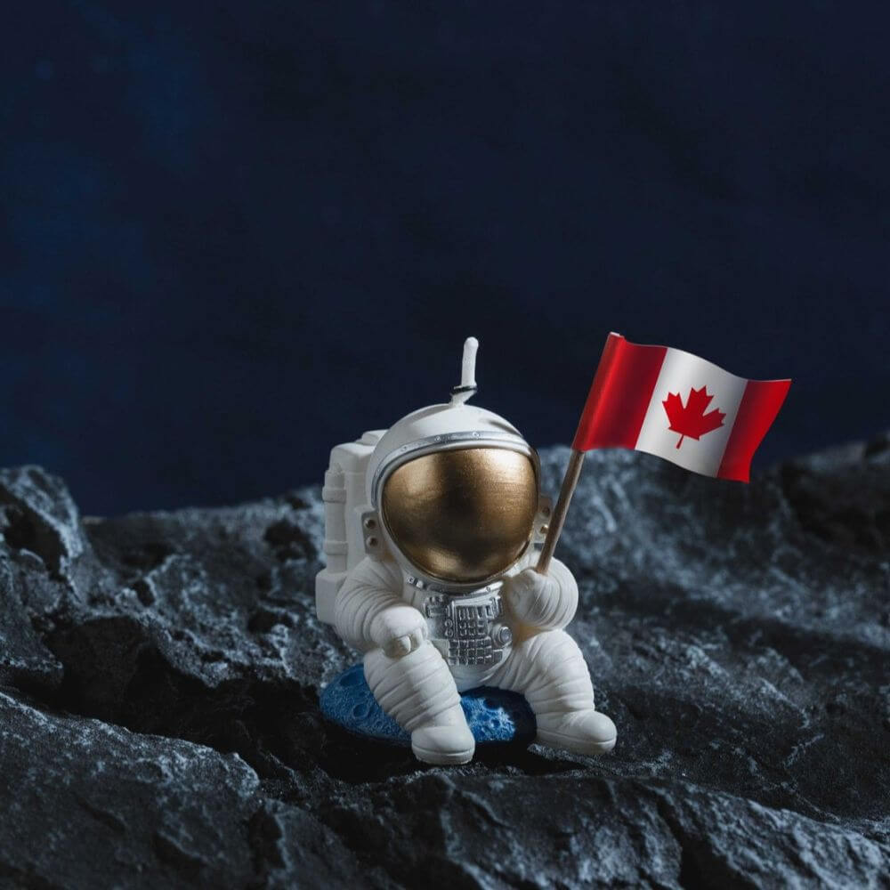 The Landing Astronaut Candle is proudly holding a Canadian flag candle for a space lover's birthday cake from Southlake Gifts Canada.