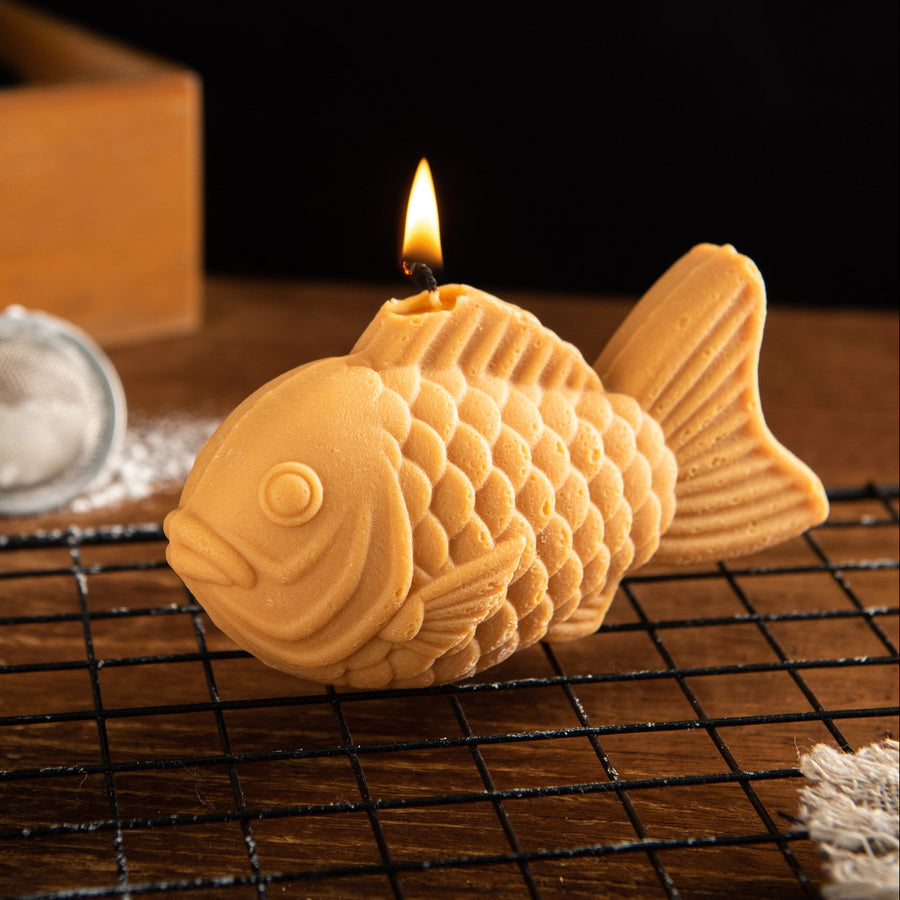 Lit Taiyaki Candle shaped like a realistic Japanese fish-shaped dessert, a unique novelty food candle for Japanese food lovers