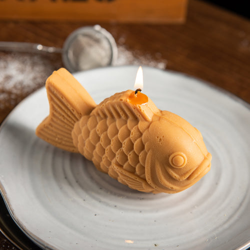 Handcrafted Taiyaki Candle lit on a plate, a realistic Japanese dessert food candle and unique novelty gift for foodies and Japan lovers