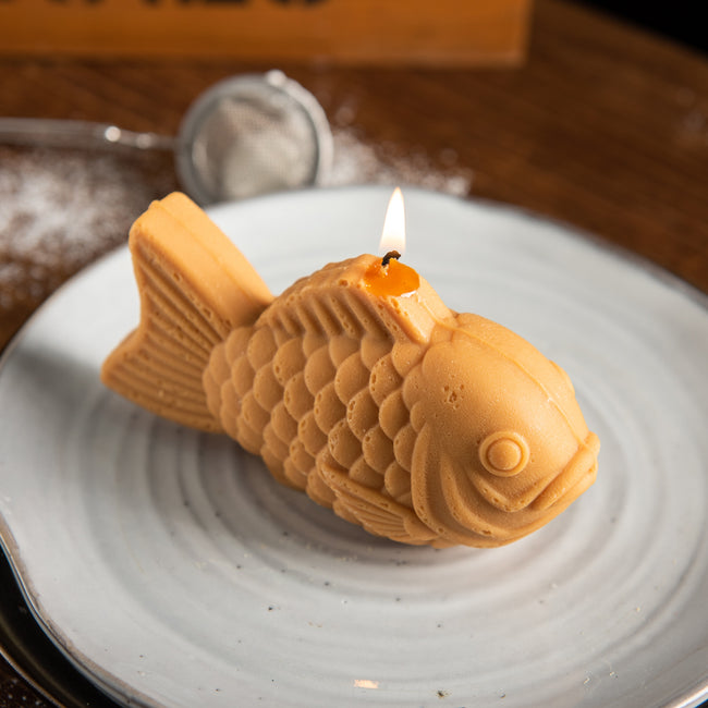 Handcrafted Taiyaki Candle lit on a plate, a realistic Japanese dessert food candle and unique novelty gift for foodies and Japan lovers
