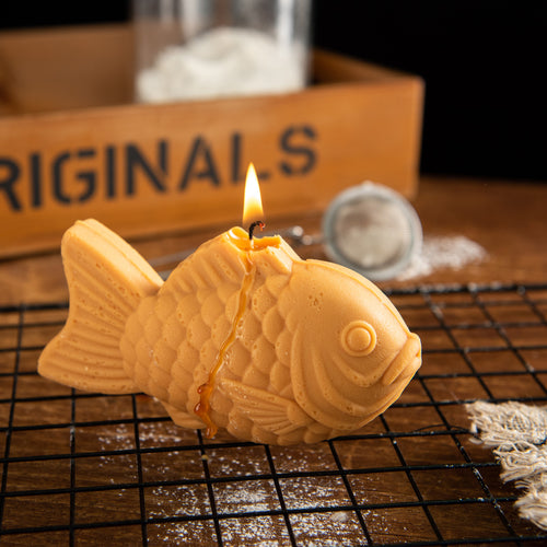 Burning Taiyaki Candle with melting soy wax, a realistic Japanese food candle and quirky novelty gift for taiyaki fans and food lovers